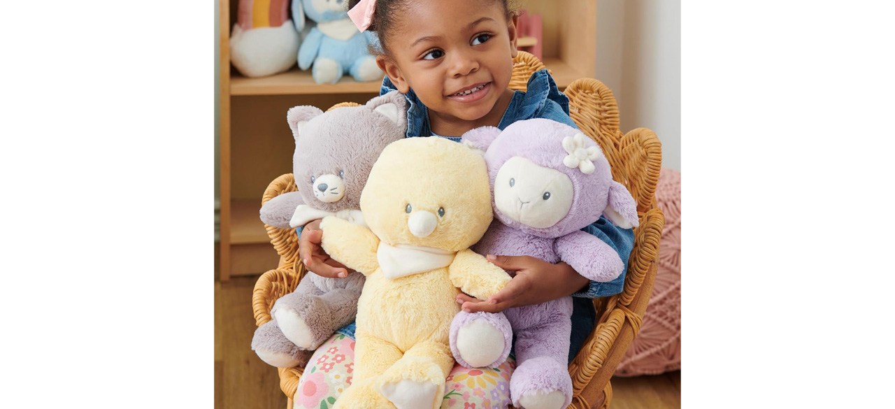 Toddler holding GUND Baby Lamb Plush