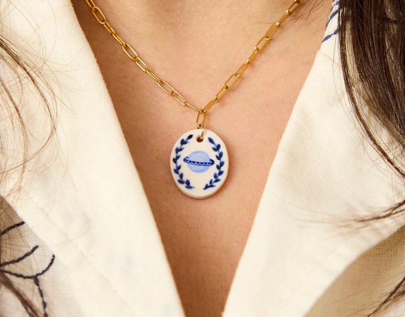 model wearing blue saturn charm