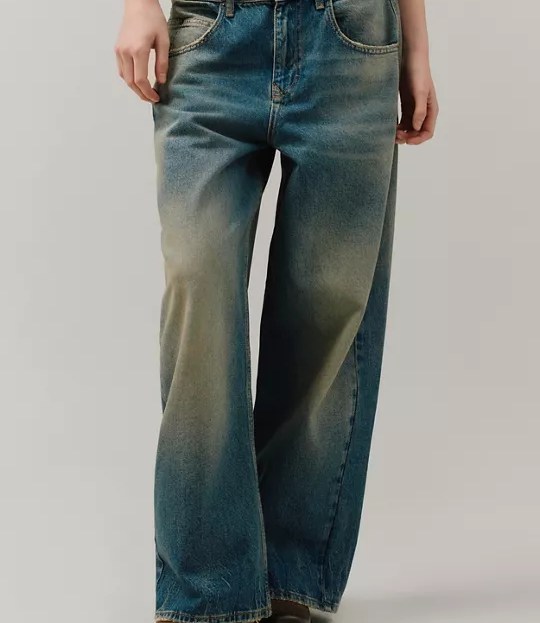 model wearing low rise acid washed baggy jeans and boots