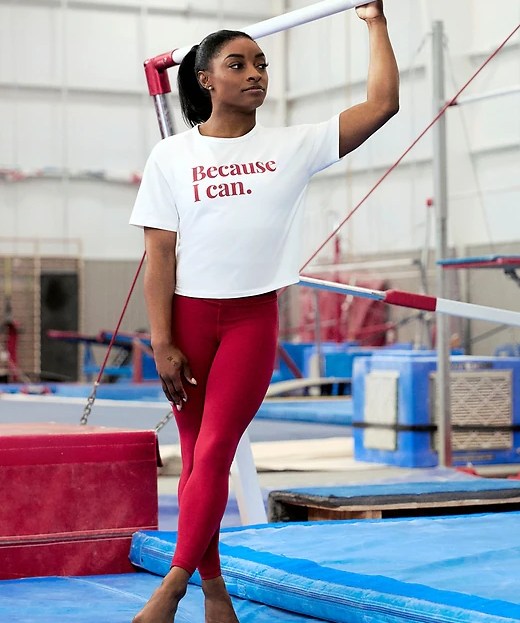 simone biles in red athleta leggings and white graphic t-shirt