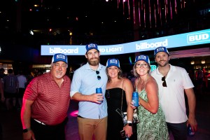 Attendees wearing Bud Light hats while holding cans of Bud Light
